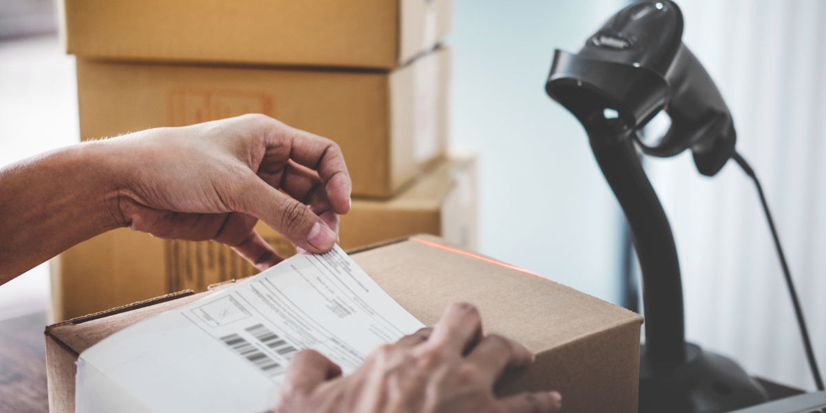 Fulfillment Facility Person beklebt ein Paket