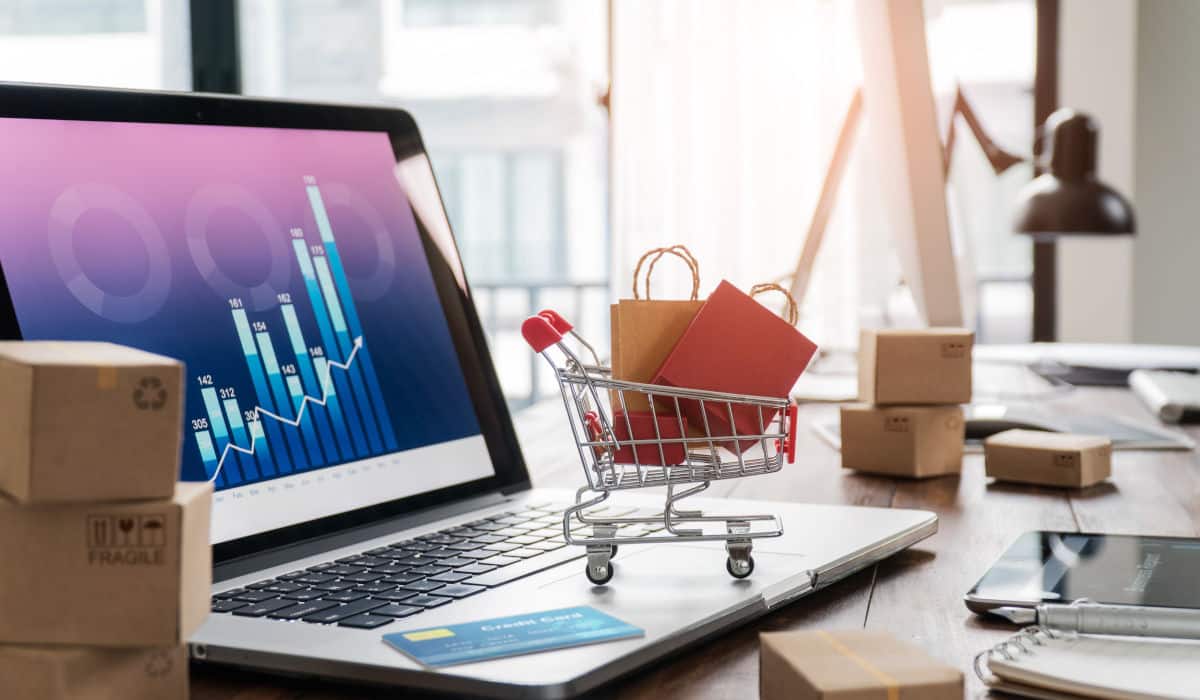 E-Commerce-Fulfillment Ein Laptop, auf dem ein kleiner Einkaufswagen steht