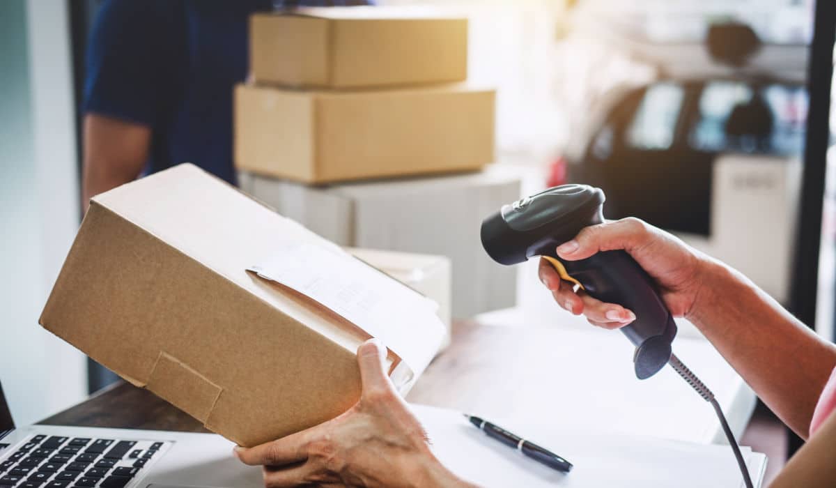 Präventives Retourenmanagement Person scannt ein Paket bei m Retourenmanagement