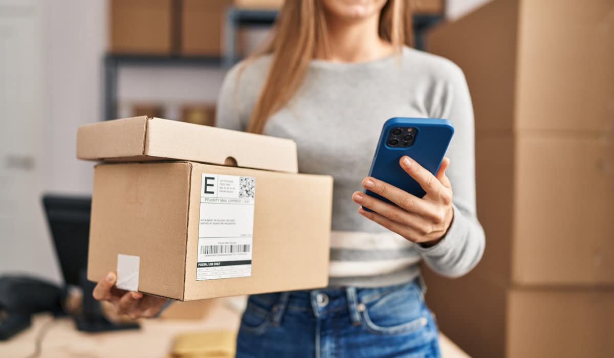 Woman holding parcels and a smartphone